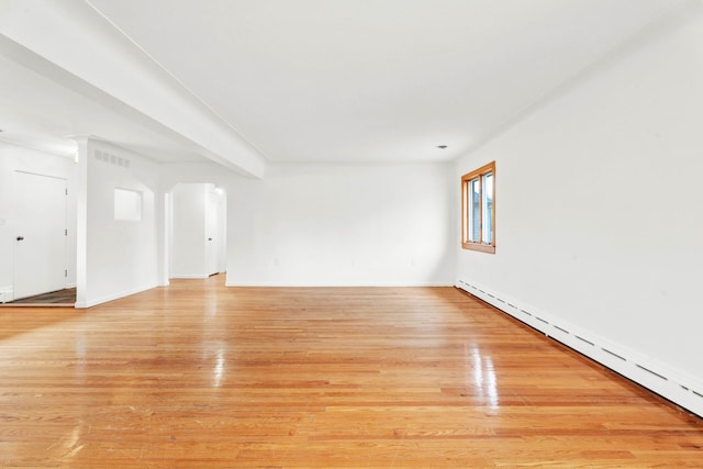 unfurnished living room featuring baseboards, visible vents, baseboard heating, and light wood-style flooring