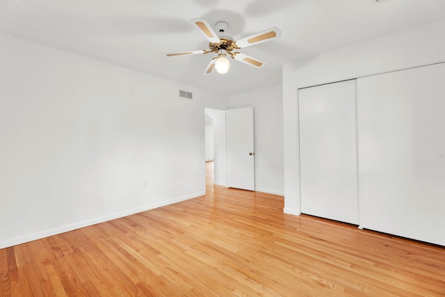 unfurnished bedroom with baseboards, visible vents, light wood finished floors, and a closet