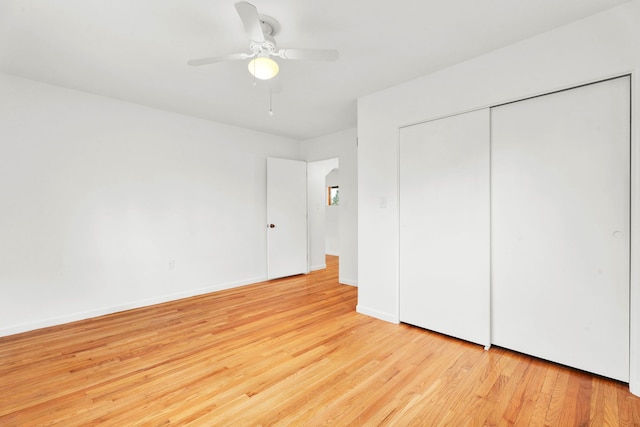 unfurnished bedroom featuring light wood-type flooring, a ceiling fan, baseboards, and a closet