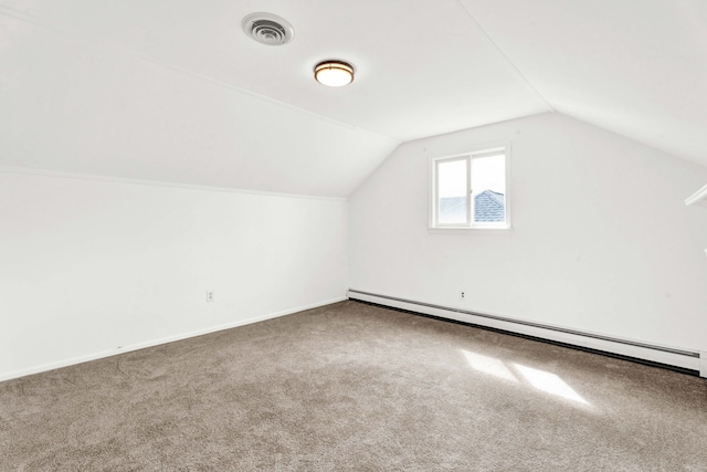 additional living space with visible vents, carpet floors, a baseboard heating unit, and vaulted ceiling