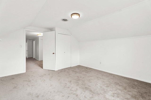 additional living space featuring carpet floors, baseboards, vaulted ceiling, and visible vents