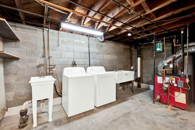 washroom with laundry area, washer and clothes dryer, a sink, and a heating unit