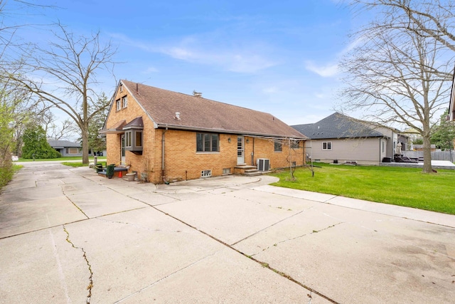 rear view of property with central air condition unit, brick siding, a yard, and a shingled roof
