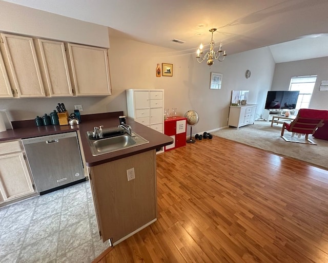 kitchen featuring dark countertops, dishwasher, a sink, a peninsula, and open floor plan