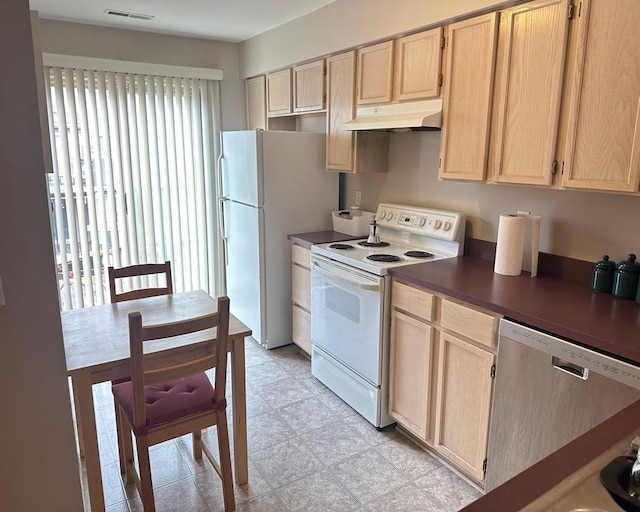 kitchen featuring light brown cabinets, dark countertops, white appliances, under cabinet range hood, and visible vents
