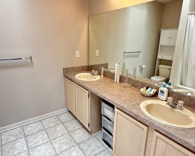 bathroom featuring a sink, double vanity, and toilet