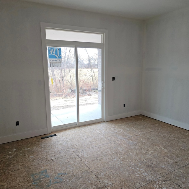 empty room featuring baseboards and visible vents