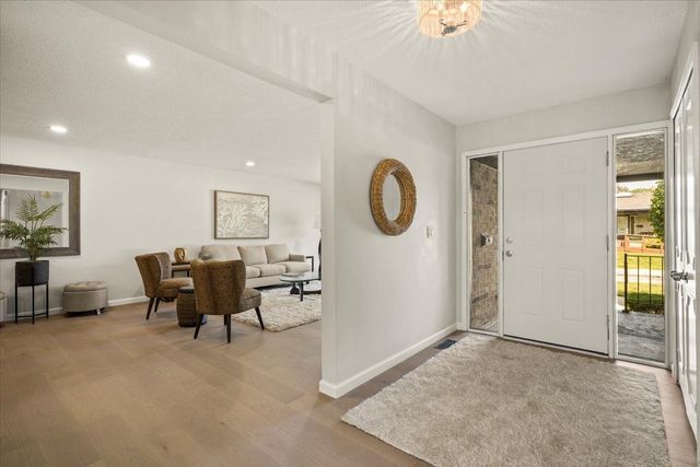 foyer entrance featuring baseboards, wood finished floors, and recessed lighting