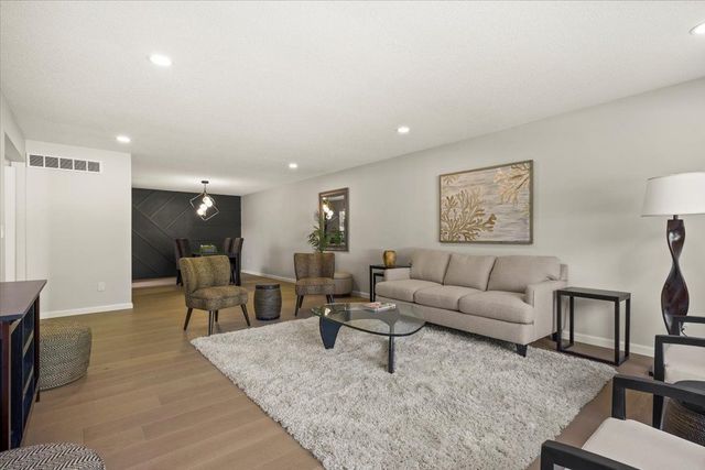 living area featuring recessed lighting, light wood-style floors, visible vents, and baseboards