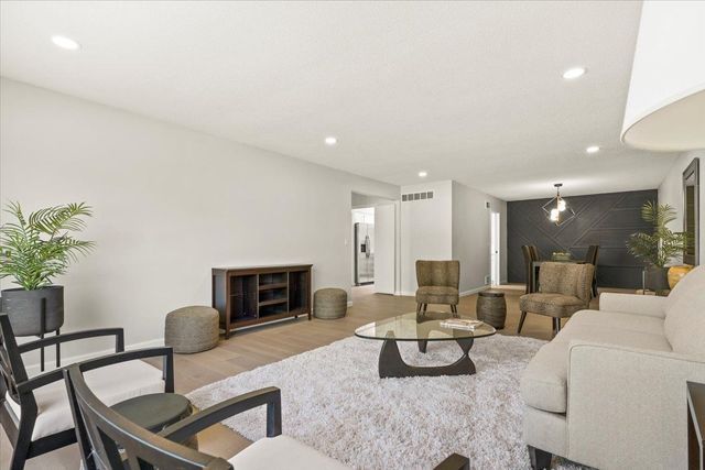 living room with baseboards, wood finished floors, visible vents, and recessed lighting