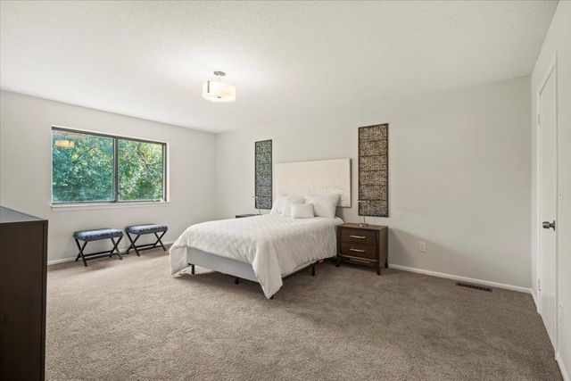 bedroom with baseboards, visible vents, and carpet