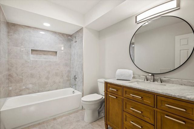 full bath with toilet, vanity, and tub / shower combination