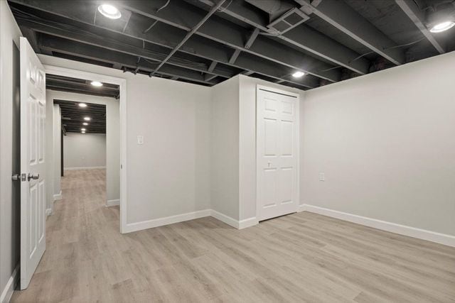 finished basement featuring baseboards and light wood-style floors