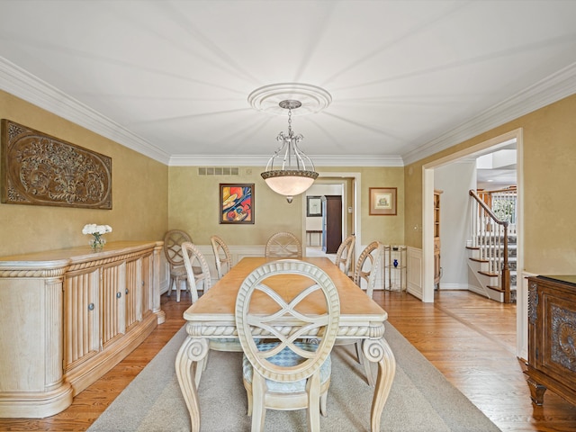 14165 Bournemuth Dr, Shelby Twp, MI 48315 - dining room with light wood finished floors, ornamental molding, stairway, and visible vents
