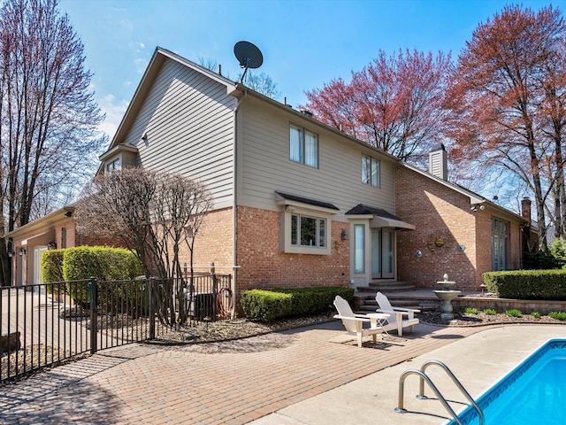 14165 Bournemuth Dr, Shelby Twp, MI 48315 - back of house featuring a chimney, brick siding, fence, and a patio