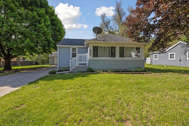 bungalow-style home with a front yard