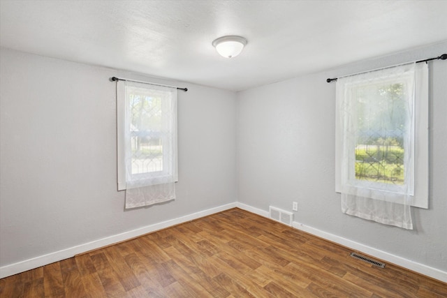 empty room featuring baseboards and wood finished floors