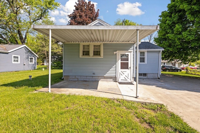 rear view of house with a lawn and a carport