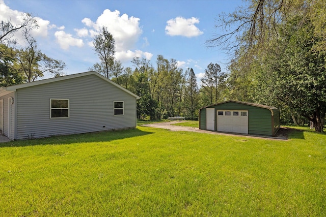 view of green lawn featuring a garage, an outdoor structure, and driveway