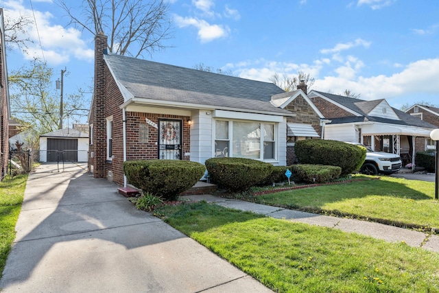 9226 Grandville Ave, Detroit, MI 48228 - view of front of home with a gate, a detached garage, a chimney, a front yard, and brick siding