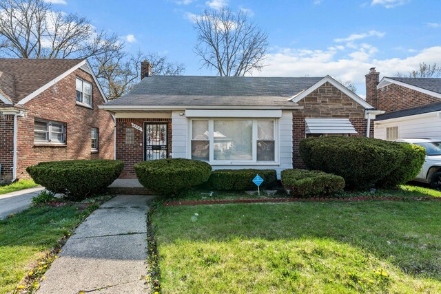 9226 Grandville Ave, Detroit, MI 48228 - view of front facade with a chimney, brick siding, and a front yard
