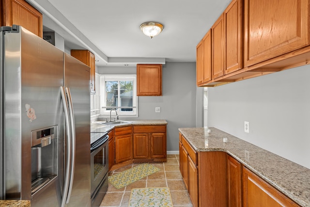 9226 Grandville Ave, Detroit, MI 48228 - kitchen with brown cabinets, light stone counters, stainless steel appliances, a sink, and light tile patterned flooring
