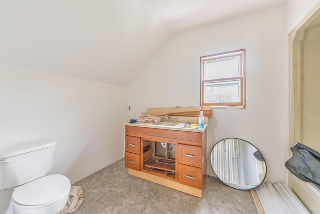 bathroom featuring lofted ceiling, toilet, and vanity