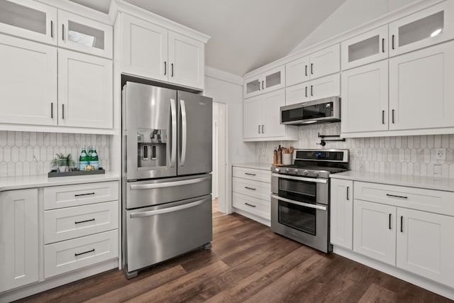kitchen with white cabinets, stainless steel appliances, dark wood finished floors, backsplash, and light countertops