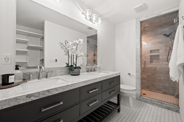 bathroom featuring toilet, a sink, double vanity, and a stall shower