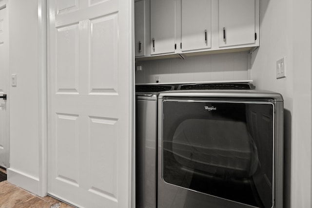 laundry area with washing machine and clothes dryer and cabinet space