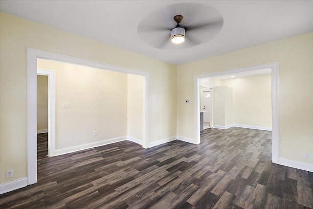 unfurnished room featuring ceiling fan, baseboards, and dark wood-type flooring