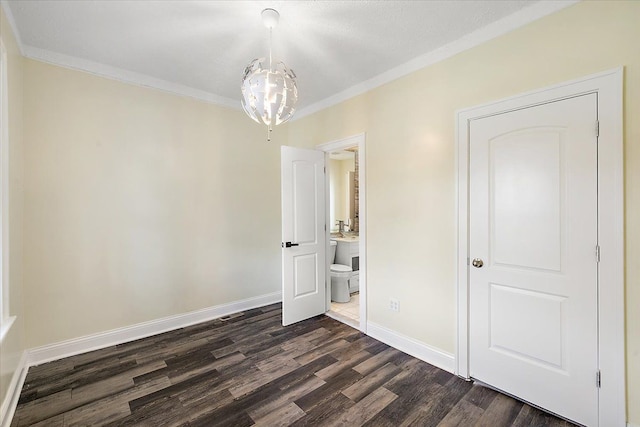 unfurnished bedroom featuring a notable chandelier, ornamental molding, baseboards, and dark wood-style flooring