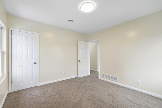 unfurnished bedroom featuring carpet floors, visible vents, and baseboards