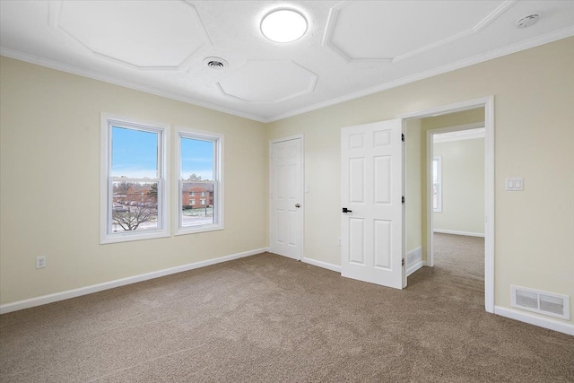 unfurnished bedroom with baseboards, visible vents, carpet flooring, and crown molding
