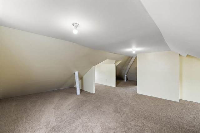 additional living space with vaulted ceiling and light carpet