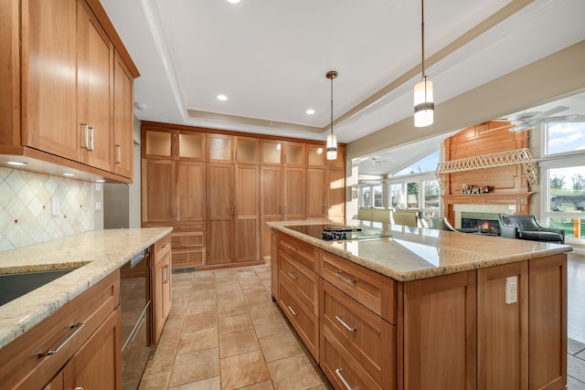 kitchen featuring decorative backsplash, black electric cooktop, a large fireplace, and a healthy amount of sunlight