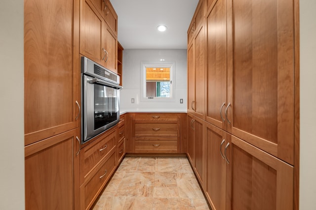 kitchen with recessed lighting, light countertops, open shelves, brown cabinetry, and stainless steel oven