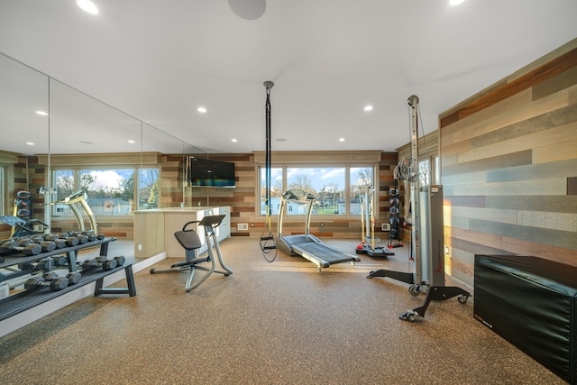 gym with recessed lighting, wood walls, and a wealth of natural light