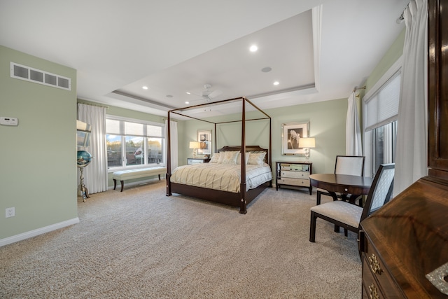 bedroom with carpet, baseboards, visible vents, and a raised ceiling