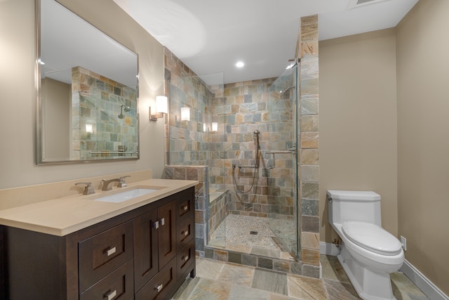 full bathroom featuring baseboards, toilet, vanity, and tiled shower