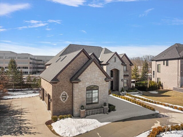 3888 Thatcher Dr, Rochester Hills, MI 48309 - french country style house with a garage, driveway, stone siding, and brick siding