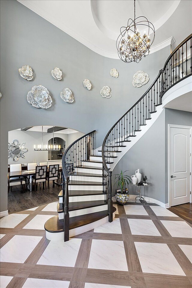 3888 Thatcher Dr, Rochester Hills, MI 48309 - stairway with baseboards, a towering ceiling, arched walkways, and a chandelier