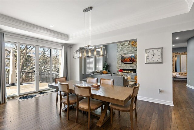 3888 Thatcher Dr, Rochester Hills, MI 48309 - dining space featuring dark wood-style flooring, baseboards, crown molding, a fireplace, and a raised ceiling