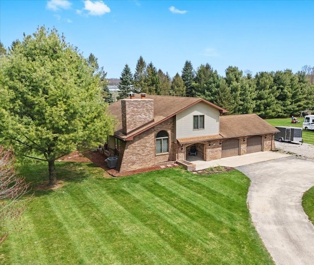 view of front facade featuring an attached garage, brick siding, aphalt driveway, a front yard, and a chimney