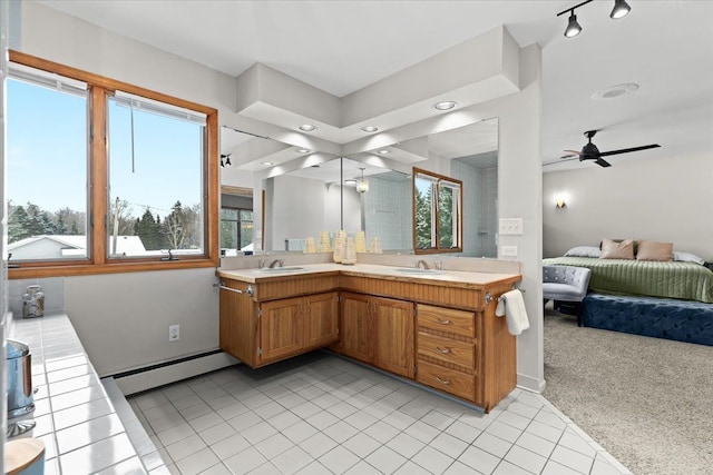 full bath with a sink, tile patterned flooring, a baseboard radiator, and double vanity