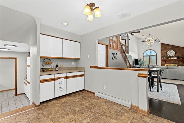kitchen featuring white cabinets, a ceiling fan, baseboards, and a baseboard heating unit