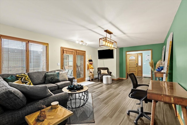 living area featuring baseboards and light wood-type flooring