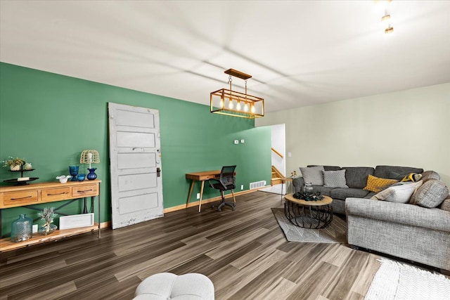 living area featuring visible vents, baseboards, stairs, and wood finished floors