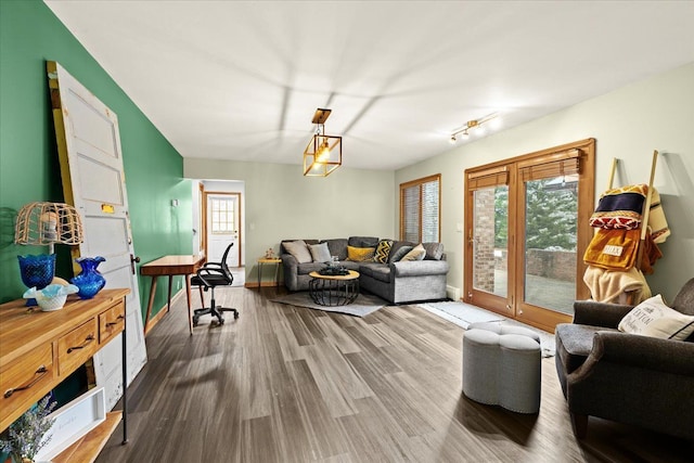 living area with baseboards and wood finished floors