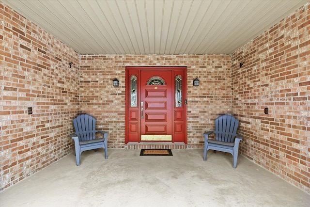 view of exterior entry featuring brick siding